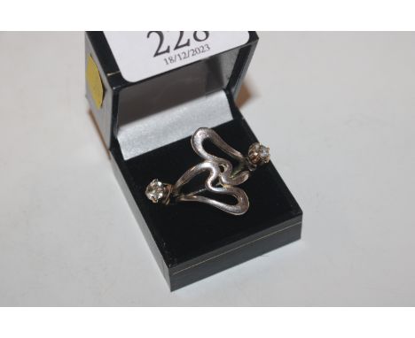 A white metal modernist ring and a pair of ear-rings set with white stones 