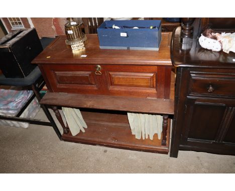 A late Victorian oak side cabinet with drop flap compartment and curtain to the lower shelf