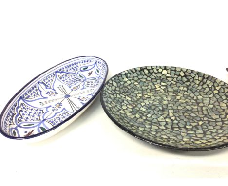 Two dishes including a mother of pearl rounded dish and a Moroccan art style oval dish . Postage cat D