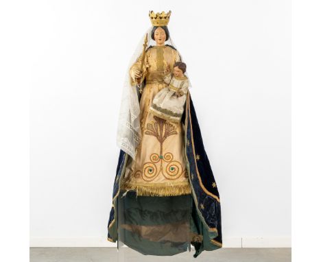 An antique wood-sculptured Madonna with a Child', finished with embroideries and brocade.A wood sculptured Virgin with a Chil