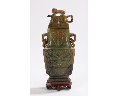 Chinese jade vase and cover, the cover with a lion above elephant mask handles holding loops, the vase carved with stylised f