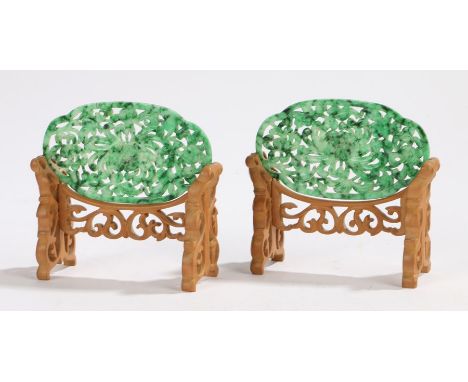 Pair of Chinese jade panels, the spinach jade carved with a central flower with open petals raised on carved stands, each pan