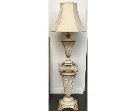 A decorative white and gold table lamp on matching base 