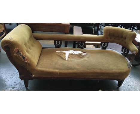 An late Victorian carved and pierced walnut chaise longue with with button back and rest and upholstered back rail, on castor