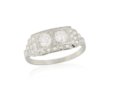 AN EARLY 20TH CENTURY DIAMOND RINGThe central panel millegrain-set with two central old European-cut diamonds, to a surround 