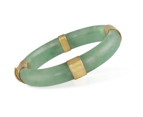 A JADE AND GOLD BANGLE BRACELETOf hinged design, the polished green jade set with polished gold panels at each quarter, mount