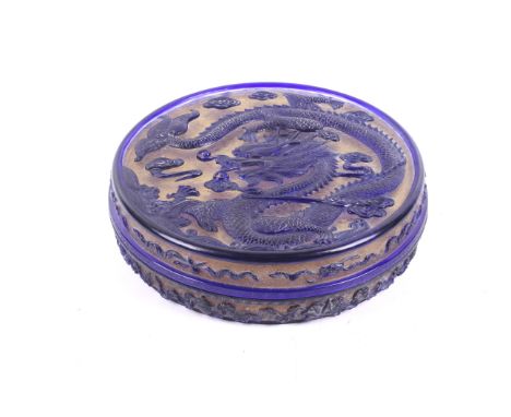 A 20th century Chinese 'Peking' glass round box. Decorated with a writhing dragon over waves in deep blue glass over a dense 