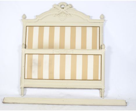 A vintage double bed frame. The wooden frame painted cream and the headboard and end board are upholstered with padded stripe