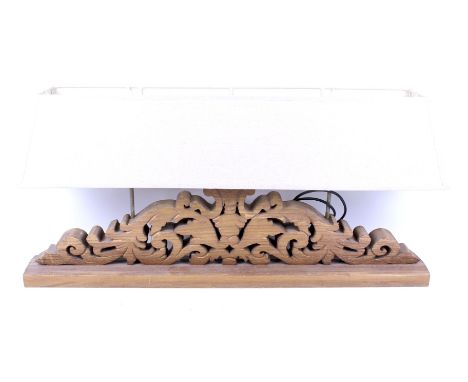A modern carved wooden table lamp. Pierced frieze, raised on a rectangular plinth with three lights and a single shade. H47cm