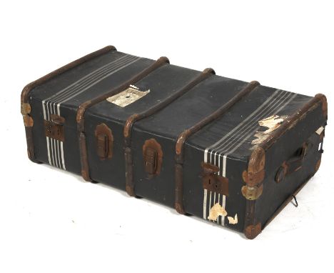A vintage steamer trunk. Coloured black with wooden reinforcements and four latches, H30cm x W91cm x D54cm