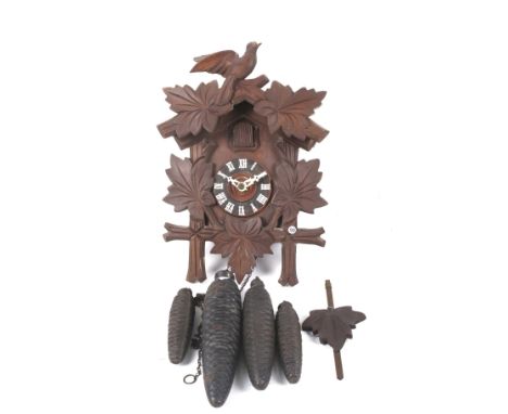 Two 20th century clocks. Comprising a Black Forest cuckoo clock with carved decoration and four weights, H32cm and a mantel c