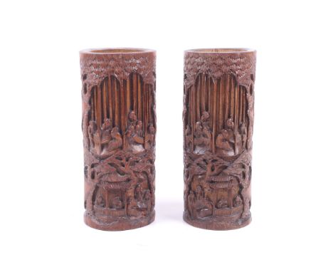 A pair of 20th century Chinese bamboo brushpots. Each deeply carved to one side with scholars in a bamboo grove playing go an