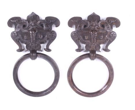 A pair of Tibetan bronze 'temple' door handles. With a mythological 'taotie' face panel with details in relief over a heavy s