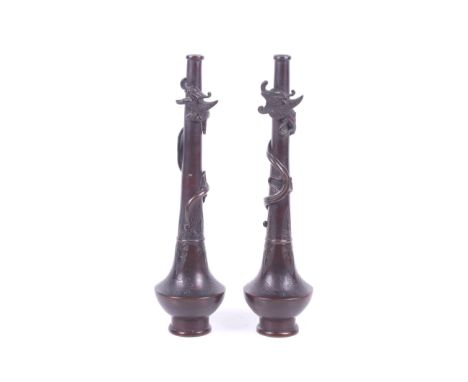 A pair of Japanese bronze vases. Of slender from, a simplified dragon winding up each column, the vase body engraved with spl