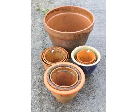 A collection of garden pots. Mostly terracotta in a good range of sizes plus two ceramic Chinese style plant stands (one dama