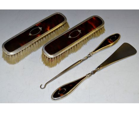 A George V silver and tortoiseshell button hook and shoe horn, en-suite with a pair of clothes brushes, Mappin & Webb, Birmin