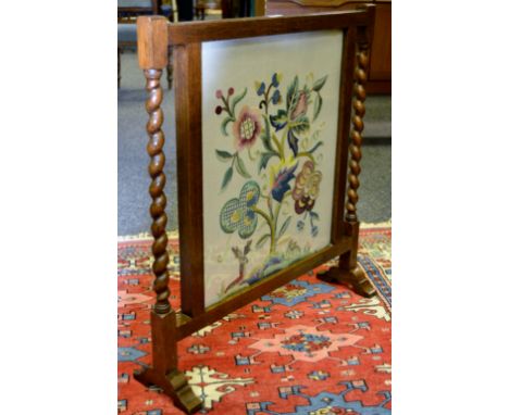 An early 20th century oak firescreen. Barley twist supports, crewel work panel c.1930