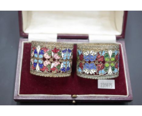Two Chinese enamel &amp; metal pierced napkin rings in an antique box