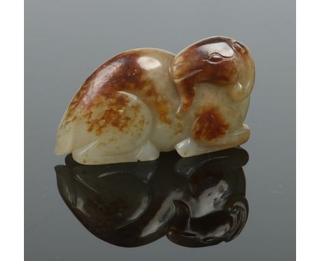 A Chinese carved russet jade model of a recumbent ram, 5.75cm.  Condition Report. To be used as a guide only. Good condition.