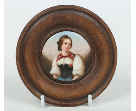 A framed Berlin porcelain portrait miniature of a Tyrolean girl, 6cm diameter.  Condition Report. To be used as a guide only.