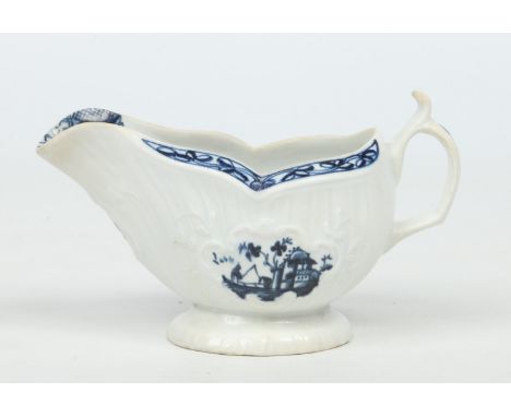 A rare Isleworth sauceboat, strap moulded and with scrolling handle. Painted in underglaze blue in the Worcester style with C