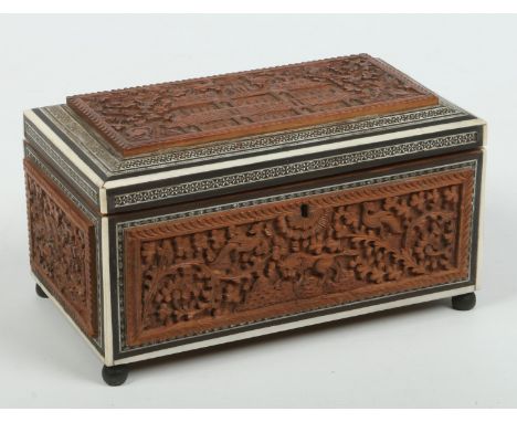 A 19th century Anglo Indian carved sandalwood Sadeli double tea caddy. With ebony and ivory mosaic banding, carved to the cov