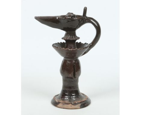 An 18th century Islamic treacle glazed terracotta pedestal oil lamp, 28cm. Condition Report. To be used as a guide only. Top 