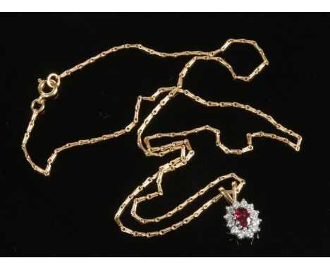 An 18 carat gold, ruby and diamond cluster pendant on barleycorn link chain. The central ovoid ruby approximately 0.5ct and w