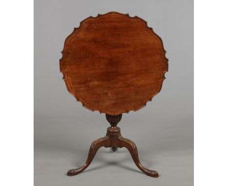 An early 19th century Irish mahogany snap top tripod table. With scalloped dish top, raised on a reeded centre pedestal and w
