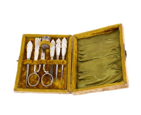 An antique eight piece sewing set. Contained within a rectangular case with a green velvet and silk interior. Containing a st