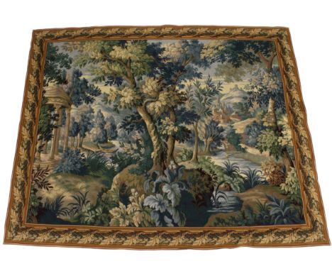 A 17th century style French high quality woven verdure tapestry. Depicting a landscape with a folly to the corner, having a b
