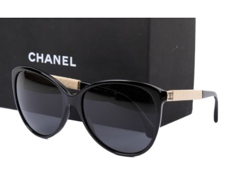 A pair of Chanel 'Butterfly' sunglasses. No.5225Q, the black frames with cream leather details to the sides, having the origi