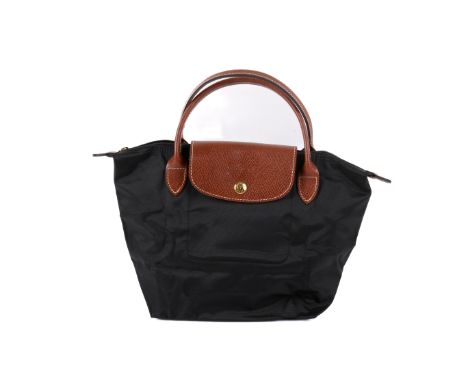 A Longchamp 'Le Pliage' foldable handbag. Constructed of black nylon with brown leather trim, thin leather handles, leather f