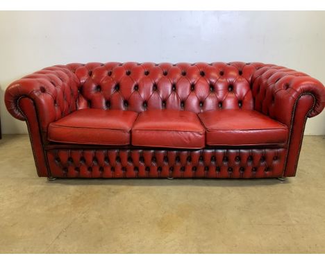 An Oxblood red leather Chesterfield three seater sofa. W:190cm x D:88cm x H:72cm