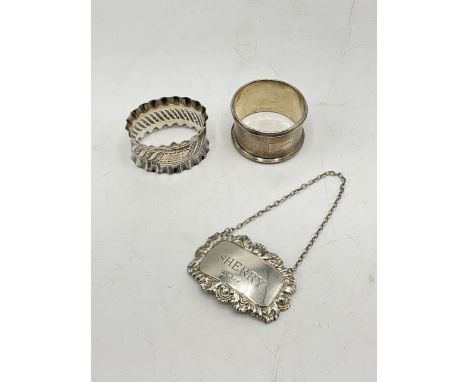 Two silver napkins rings and a silver Sherry label. Both napkin rings with personal engravings. Fluted napkin ring hallmark f