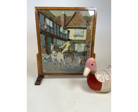 An Art Deco oak fire screen with tapestry scene of a huntsman and dog also with a duck door stop.W:60cm x H:65cm