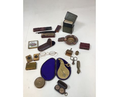 A cased brass pendulum letter scale, a full and half sovereign holder, a pair of yellow metal glasses,  match box covers, a c
