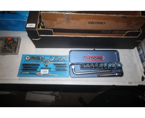 A cased tap and die set; a cased socket set; cased step drill bits etc.