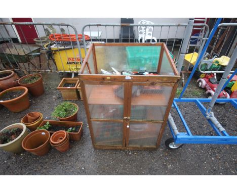 A greenhouse cupboard, lacking lid, a small quantity of plastic plant pots, small galvanised watering can, wooden trug basket