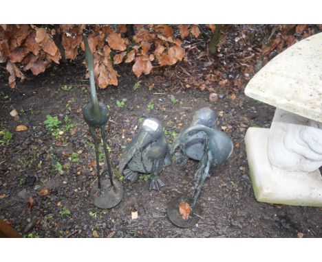 Two garden penguin ornaments and two standing heron ornaments