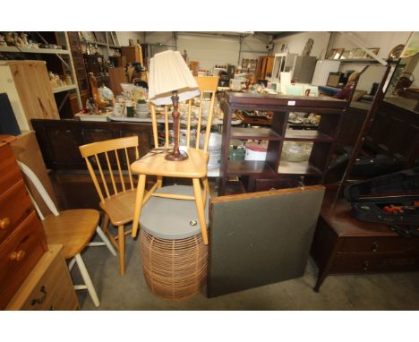 A hardwood shelving unit, card table, a wicker based table, two stick back dining chairs and a table lamps