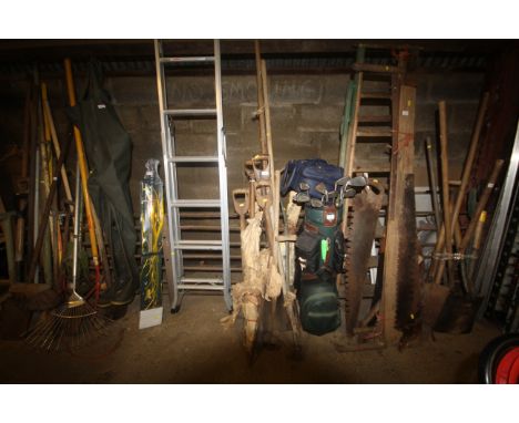A quantity of gardening tools to include a hoe; a fork; a spade; a scythe blade etc.