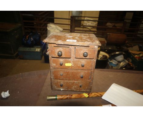A small table top chest comprising two short over three long drawers with some contents of tools 