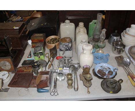 A collection of vintage items to include oil lamps, enamel chamber sticks, advertising tins, stoneware bottles etc
