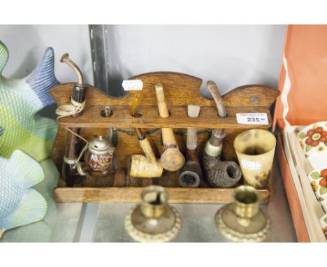 AN OAK PIPE RACK AND SIX VARIOUS TOBACCO PIPES AND A HORN BEAKER