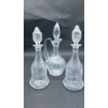 Three antique cut and engraved blown glass decanters. A pair with engraved vine design and bell