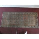 An Eastern rug with repeating gul motifs across the madder field within highly stylised foliate