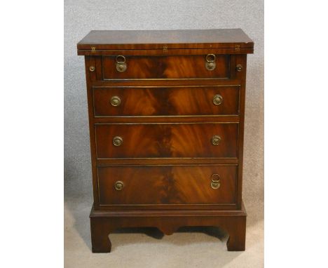 A Georgian style mahogany bachelor's chest with foldover top resting on slides above four drawers on shaped bracket feet. H.8