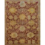 A Ziegler style carpet with repeating meandering vine and palmette design on a deep burgundy