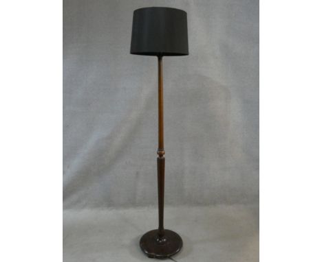 A vintage mahogany standard lamp on turned and facetted column on platform base. H.174cm 